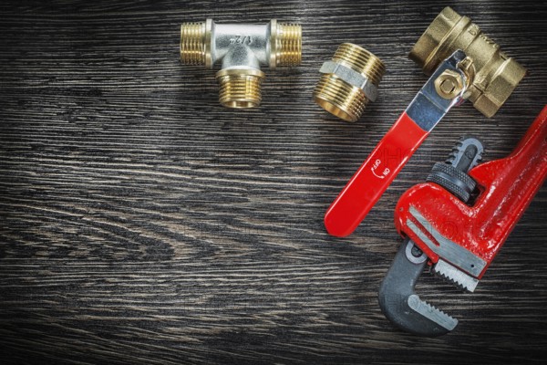 Sanitary monkey spanner connections water valve on vintage wooden board