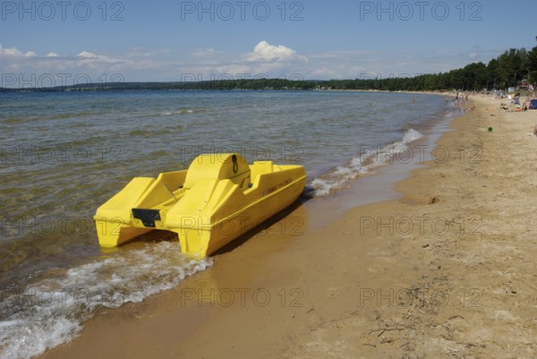 Yellow pedalo on the beach in Varamon, Motala, Sweden, Europe