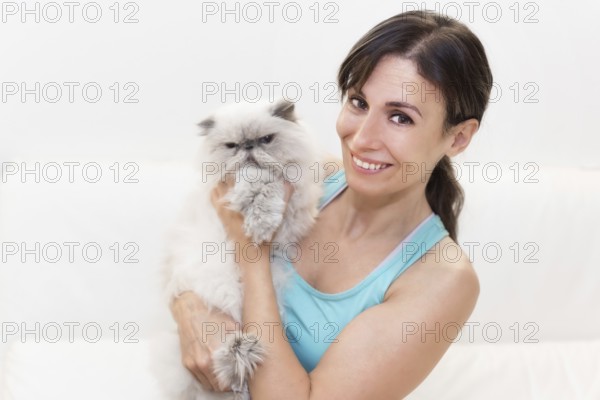 Young woman holding a persian cat