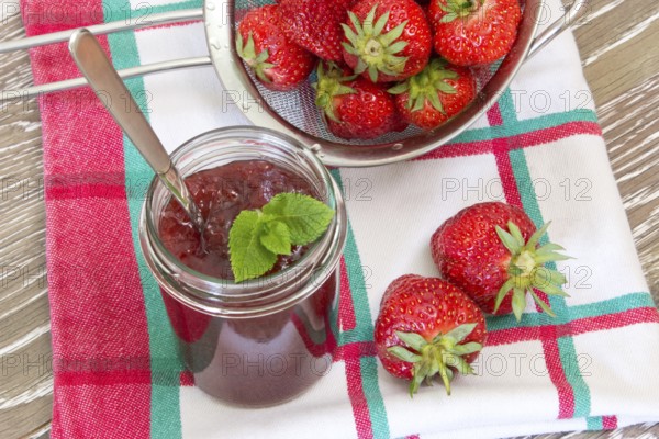 Homemade strawberry jam with fresh fruits in a sieve Home made strawberry jam with fresh fruits in a sieve