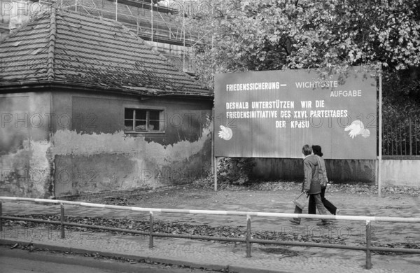 08.10.1981 GDR East Berlin district of Prenzlauer Berg. Agitation poster on a damaged house in Dimitroffstrasse. Berlin