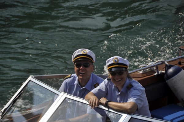 A smiling couple of water-police-officers on the Limmat-River with the major of Zürich City on board