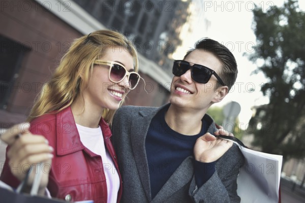 Portrait of a couple with shopping bags in the city.People, sale, love and happiness concept