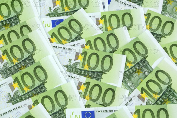 Many one hundred euro banknotes lying next to each other. Symbolic photo for wealth and investment