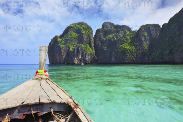 Boat trip on the native boat. Sea water is emerald green and the islands covered with green plants. Thailand