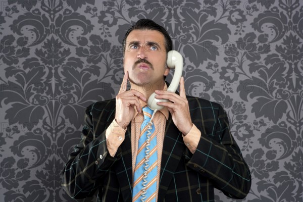 Businessman with scared expression talking by telephone with retro mustache