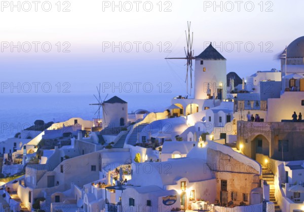 Iconic view of Oia village Santorini with windmills at sunset, Greece, Europe