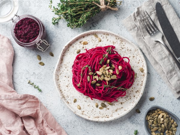 Beetroot pesto or hummus. Homemade beet pesto sauce in glass jar and fresh thyme on dark black background. Copy space for text. Ideas and recipes for healthy vegetarian detox diet food