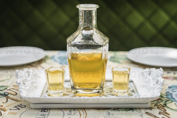 Carafe with honey vodka on white elegant tray