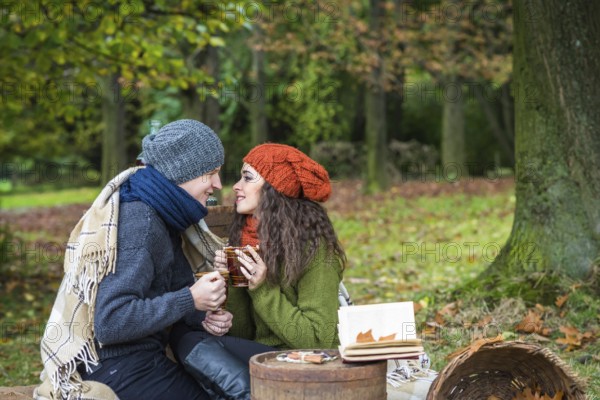 Loving young couple sitting in the autumn garden