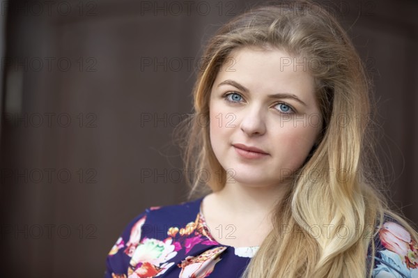 Portrait of a blonde girl with blue eyes. A girl with a European style face