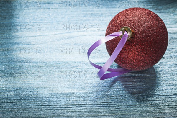 Red shining Christmas ball on wooden board holidays concept