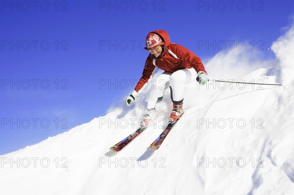Skiers in action, descent on a slope, deep snow