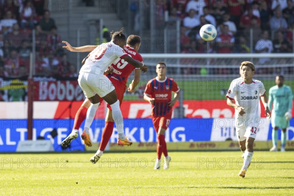 Football match, Junior ADAMU SC Freiburg left and Jonas FÖHRENBACH 1. FC Heidenheim in aerial combat for the ball, Ritsu DOAN SC Freiburg on the right, Voith-Arena football stadium, Heidenheim
