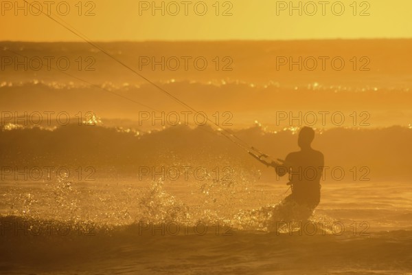 Single surfer at sunset on a calm ocean