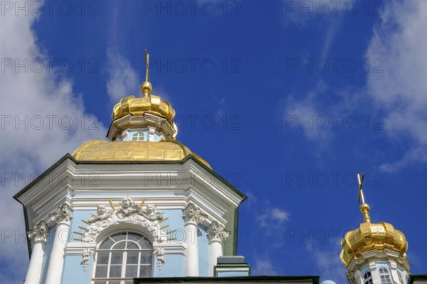 Baroque building with a blue façade and magnificent golden domes against a deep blue sky in St. Petersburg