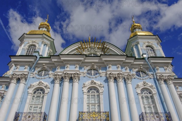 A magnificent church with golden domes, a blue façade and white columns
