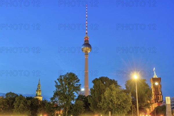 The famous television tower with the towers of St Mary's Church and the town hall in Berlin at night