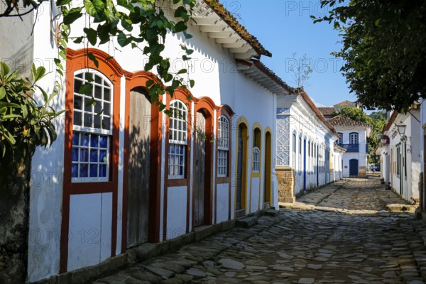 Typical cobblestone street with colorful colonial buildings in the late afternoon sun and shadows in historic town Paraty, Brazil, South America