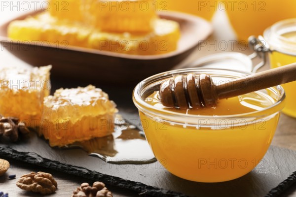 Honeycomb on slate tray with honey and nuts on kitchen table, food photography, food photography