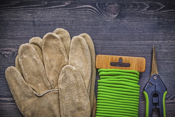Set of garden shears tie wire safety gloves on vintage wood board gardening concept