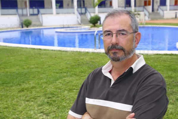 Senior retired man glasses relax on vacation garden pool