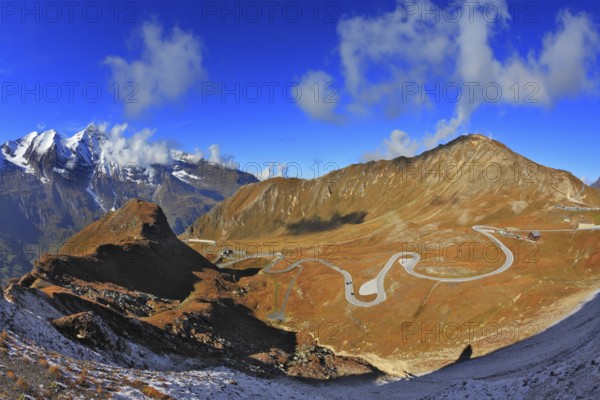 Austrian Alps. Excursion to the picturesque panoramic way Grossgloknershtrasse. Sunny day in early autumn. Great highway winds between hillsides yellowed