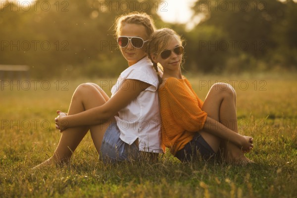 Two teenage girls have fun in the park. Two friends outdoor. Summwer people in glasses