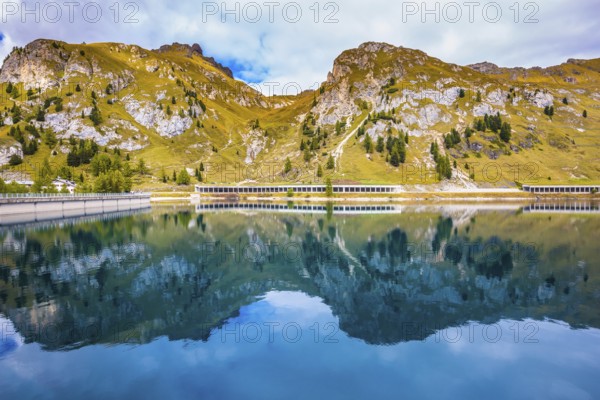 Mountain Lake Lago di Fedadia, Dolomites. Glacial lake with clear cold water. Cool autumn day at Mount Marmolada. The concept of ecological and extreme tourism