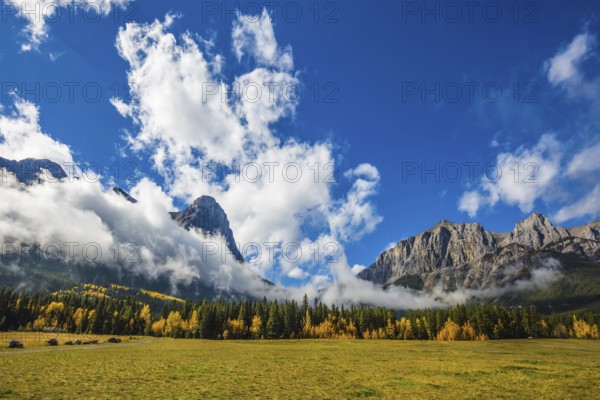 Concept of hiking. Auroral sunny day in Canmore. The famous Three Sisters mountains in the Canadian Rockies of Canada