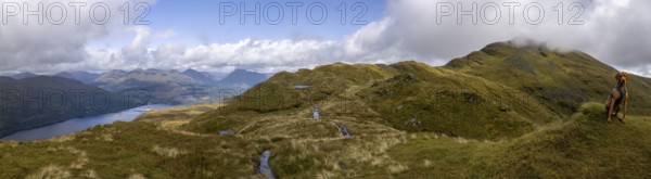 Panorama on the summit path to Ben Lomond with mountain lake and male Magyar Vizsla, Loch Lomond and the Trossachs National Park, Scotland, Great Britain