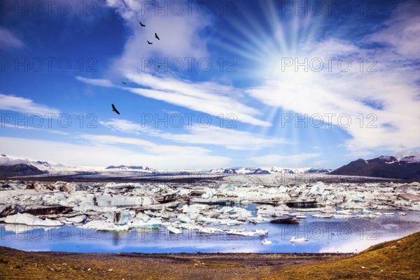 The concept of extreme tourism. Ice floes are reflected in the water surface lake. Cool northern sun illuminates the Ice Lagoon, Iceland, Europe