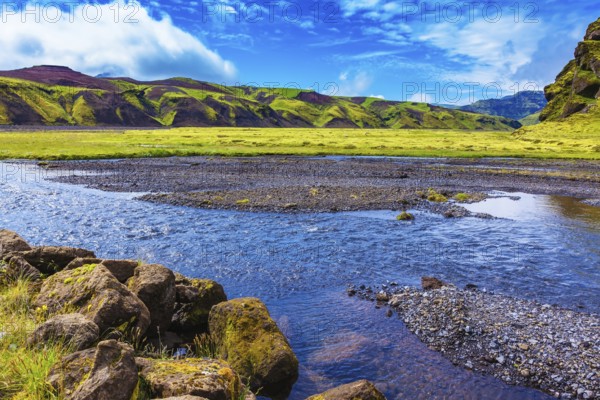 On bottom of canyon many streams flow. Canyon Pakgil in Iceland. Picturesque basalt hills overgrown green grass and moss