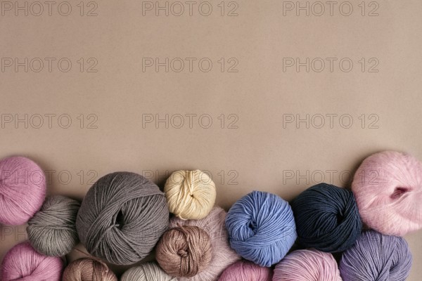 Set of colorful wool yarn on beige background. Knitting as a kind of needlework. Colorful balls of yarn and knitting needles. Top view. Still life. Copy space. Flat lay