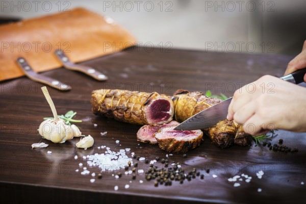 Serving carving roast pork meat roll meal in rustic style with seasonings
