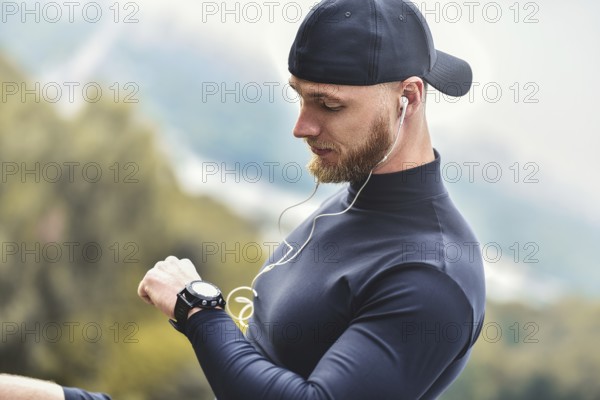 Close-up Shot Bearded Sportive Man After Workout Session Checks Fitness Results. Adult Guy Wearing Sport Tracker Wristband