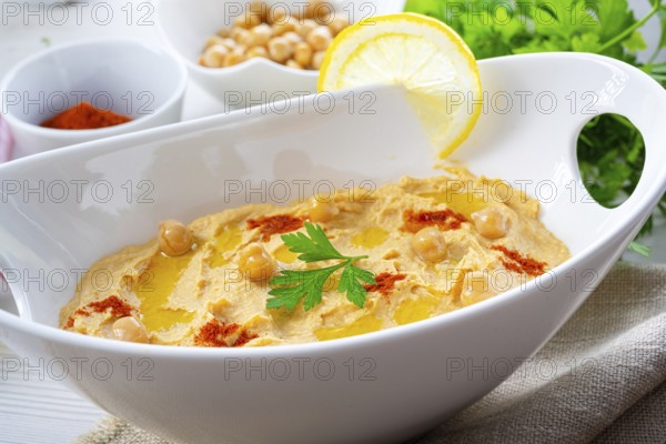 Hummus paste with lemon and chilli on a white background
