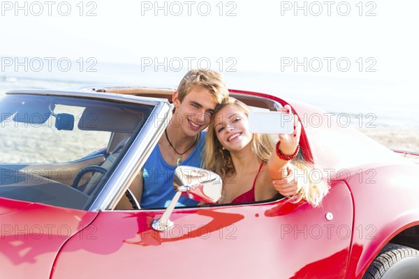 Selfie photo of young teen couple in convertible sports car