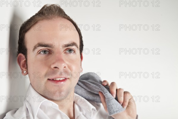 Portrait of relaxed young man leaning to white wall, Belgium, Europe