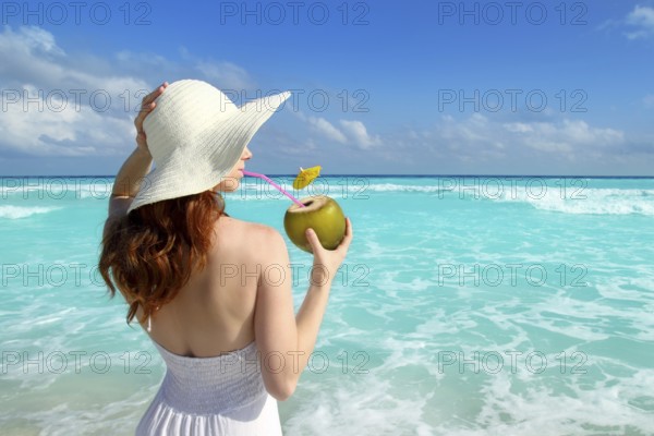 Beach hat profile girl drinking acoconut fresh cocktail in tropical Caribbean sea