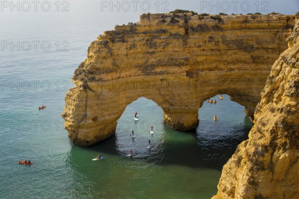 Lagoa, Portugal, September 2022: Kayaks and sup boards peddling under the Arco Natural on the Algarve coast in Portugal, Europe