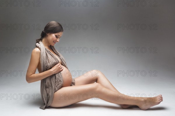 Young pregnant woman in studio in lingerie
