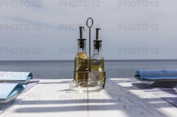 Bottle with vinegar and oil on a restaurant table, Perissa, Santorini Island, Cyclades, Greece, Europe
