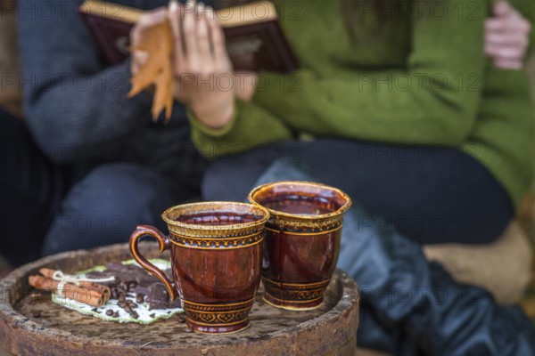 Two cups of coffee are on wooden barrel