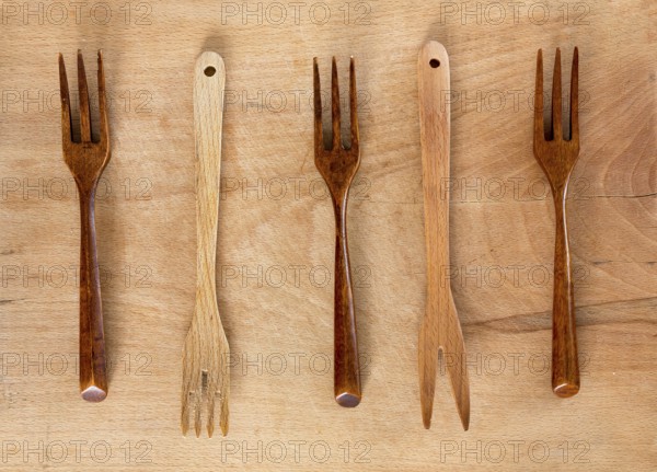 Wooden forks on a wooden background from above. Studio shot. Kitchen utensil
