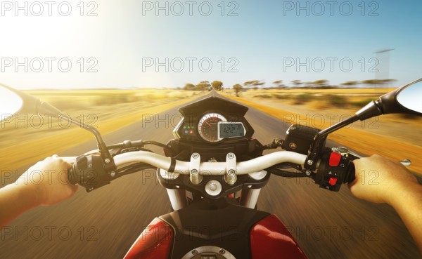 Biker driving a motorcycle rides along the country road, morning scene . First person angle view