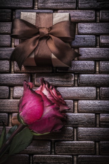 Red scented rose present box on wicker wooden place mat