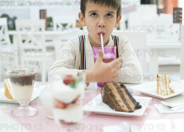 Child drink lemonade. Cake and a milkshake in confectionery