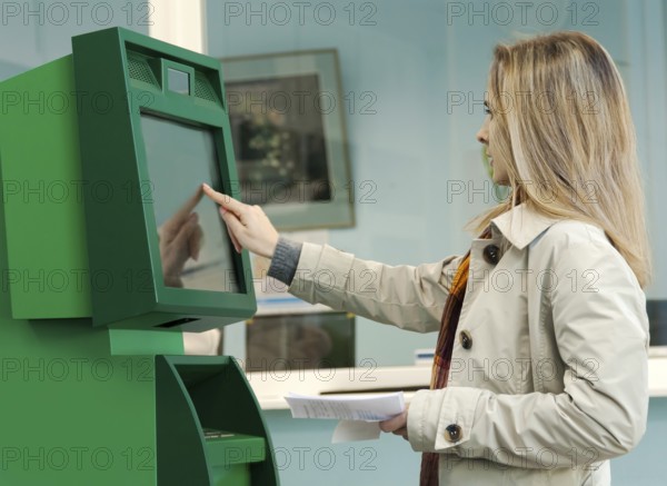 Girl pays the utility bills via ATM