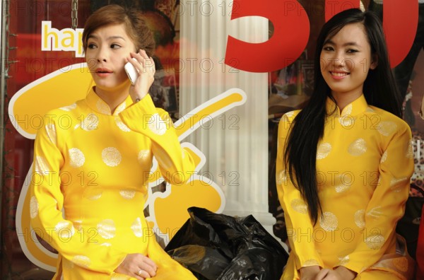 Saigons Beauties: Two woman preparing for the new year celebration. Two young beautifully dressed woman preparing for the new year celebration